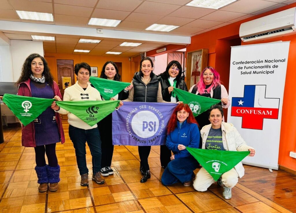 Fotografía en la que posan representantes de OLA, Comité de Mujeres de la Internacional de Servicios Públicos (ISP), Confederación Nacional de Profesionales Universitarios de los Servicios de Salud (FENPRUSS) y Confederación Nacional de Funcionarios y Funcionarias de la Salud Municipal (CONFUSAM)