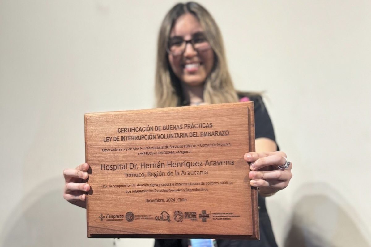 Profesional Equipo IVE posando a la cámara con reconocimiento de Certificación de Hospital Dr. Hernán Henríquez Aravena de Temuco entregado por OLA 
